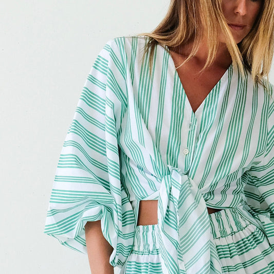 Woman wearing a green and white striped dress on a white background