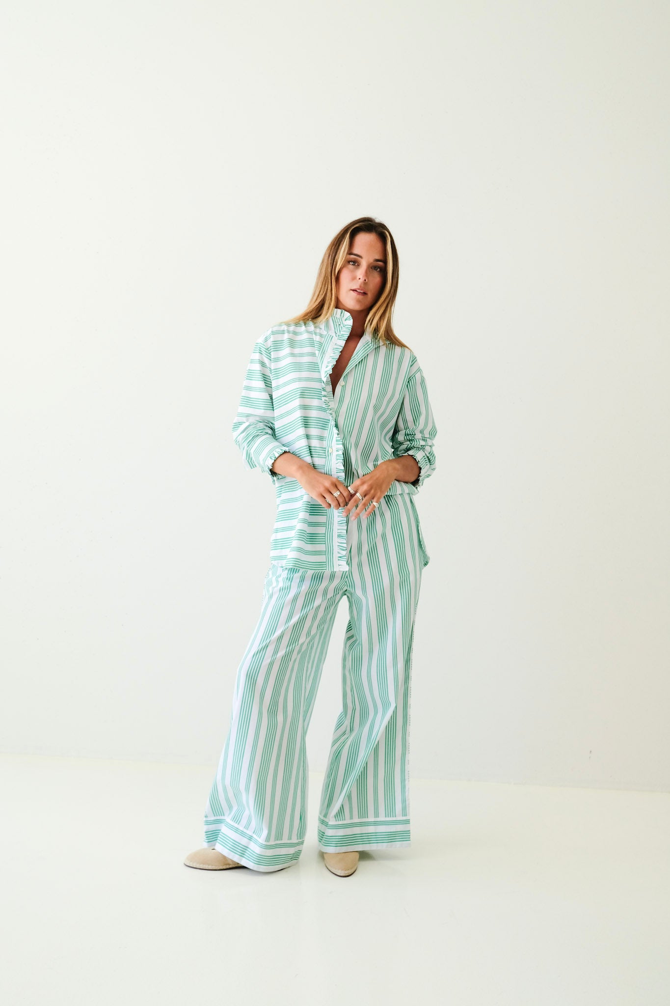 Woman wearing a striped pajama set on a white background