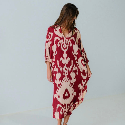 Woman wearing a red and white patterned dress on a plain background