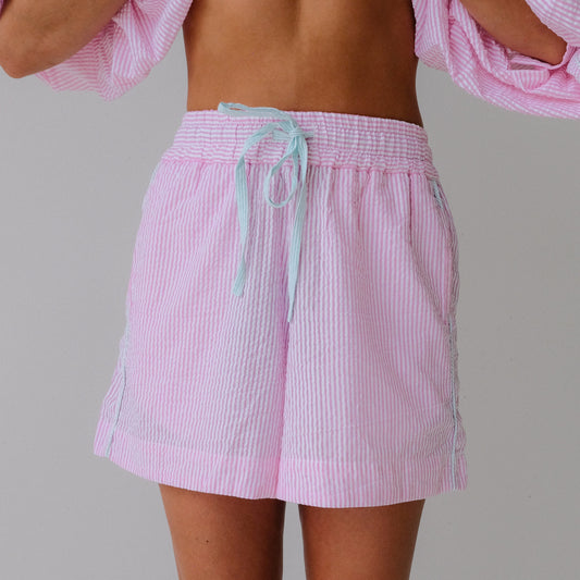 Person wearing a pink checkered outfit with a plain background