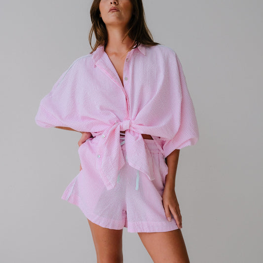 Woman wearing a pink outfit with a plain background