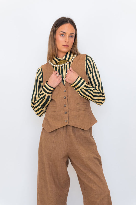 Model wearing Chocolate Prince of Wales barrel pants with a matching check vest and striped shirt.
