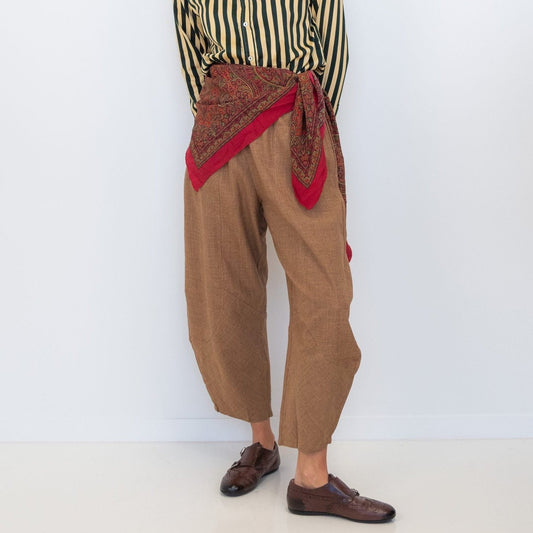 Model wearing Chocolate Prince of Wales barrel pants with a striped shirt and red scarf tied at the waist.