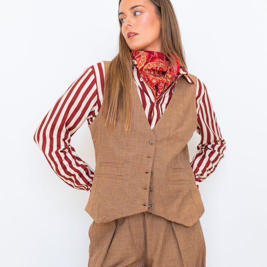 Model wearing the Chocolate Prince of Wales Vest over a red-and-white striped shirt with matching check trousers and a red scarf.