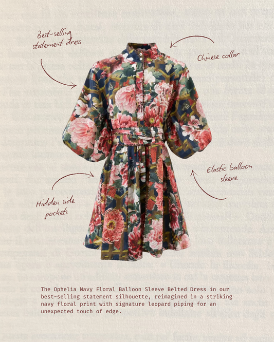 A floral belted dress with balloon sleeves and a Chinese collar, shown on a textured beige background with handwritten callouts and descriptive text. The dress features a bold multicolor floral print with pink, red, green, and blue tones.