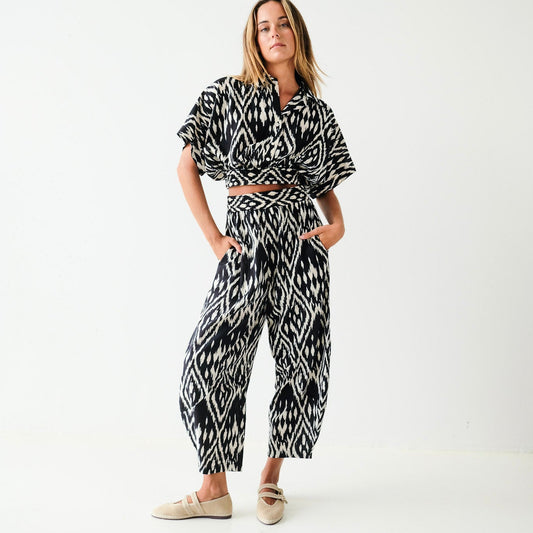 Woman wearing a black and white patterned outfit on a white background