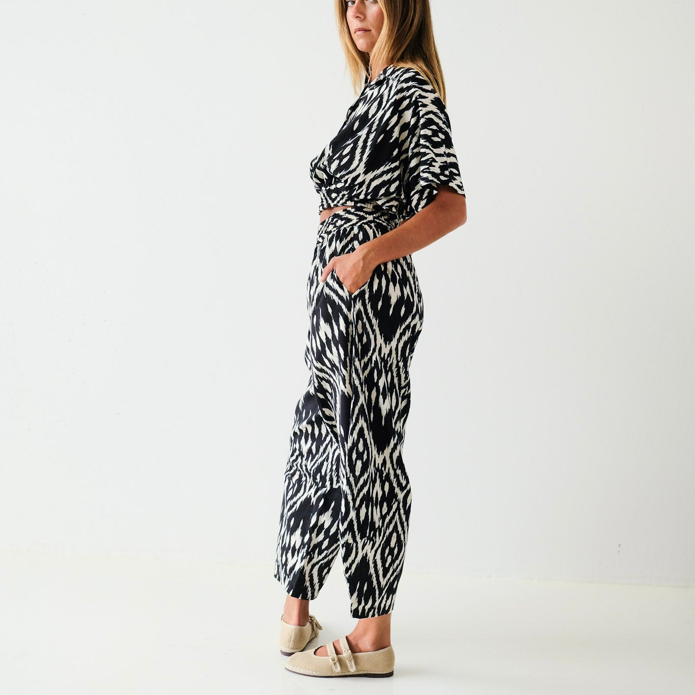 Woman wearing a black and white patterned dress on a white background