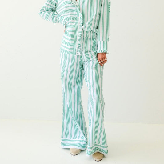 Person wearing a green and white striped set on a white background