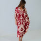 Woman wearing a red and white patterned dress against a plain background