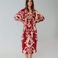 Woman wearing a red and white patterned dress on a plain background