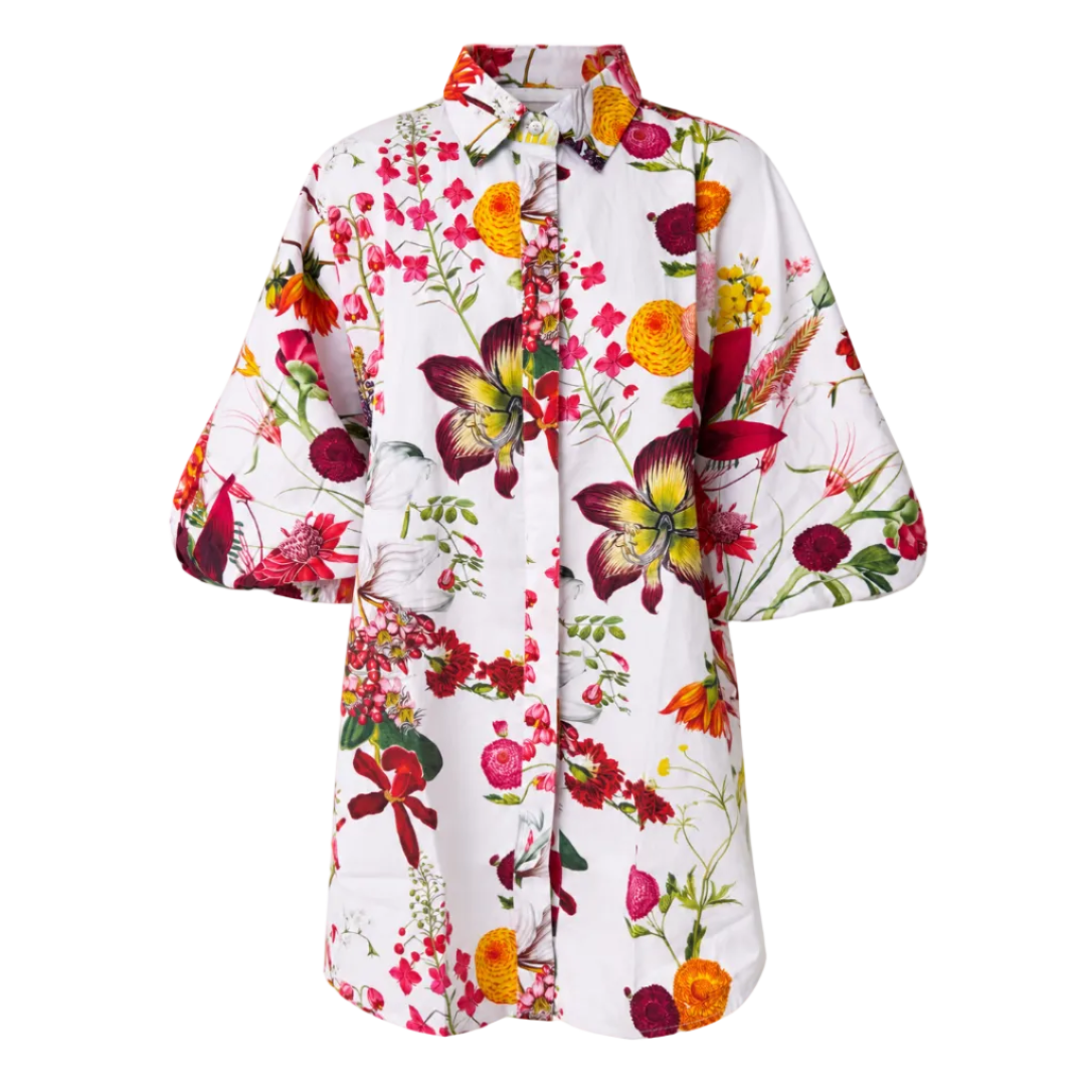 A white short-sleeve button-up shirt with a vibrant, multicolor botanical and bird print, featuring red, yellow, and orange flowers, green leaves, and birds, shown against a plain white background.
