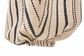 A close-up of a textured woven fabric with vertical black dotted and dashed stripes on a warm beige background, gathered at the bottom against a white backdrop.