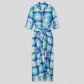 A long-sleeve plaid shirt dress in shades of blue, green, and white, featuring a button-down front, chest pocket, and a self-tie belt at the waist.