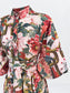 A close-up of a belted kimono-style top featuring a busy, multicolor floral and geometric print with pink, red, green, and gold tones on a light background.