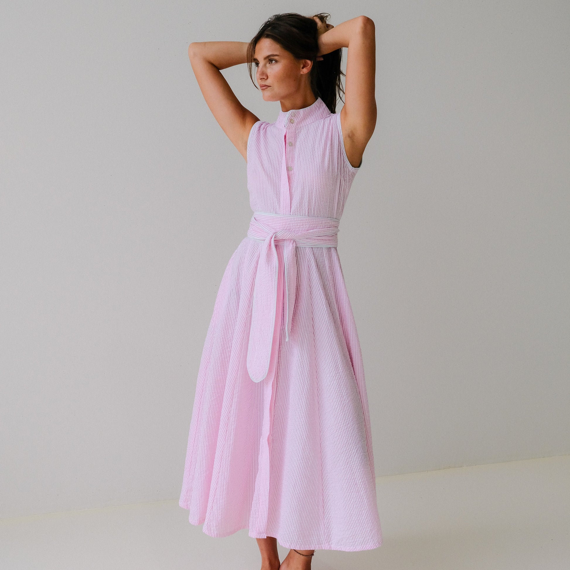Woman wearing a pink dress against a plain background