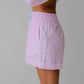 Person wearing a pink checkered skirt on a plain background