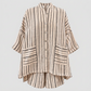 A beige and black vertically striped button-up shirt jacket with three-quarter sleeves and two front patch pockets, shown on a plain white background.