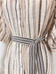 Close-up of a beige woven shirt dress with black vertical dotted stripe patterns and a matching self-tie belt at the waist.