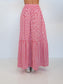 A red and white gingham tiered maxi skirt shown from the back on a model, paired with silver sneakers, against a plain white studio background.
