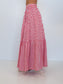 A red and white gingham tiered maxi skirt shown from the back on a model, featuring an elastic waistband and two ruffled tiers, set against a plain white studio background.