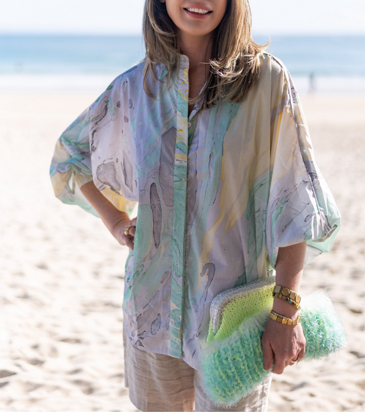 Woman wearing a colorful kimono-style garment on a beach