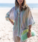 Woman wearing a colorful kimono-style garment on a beach