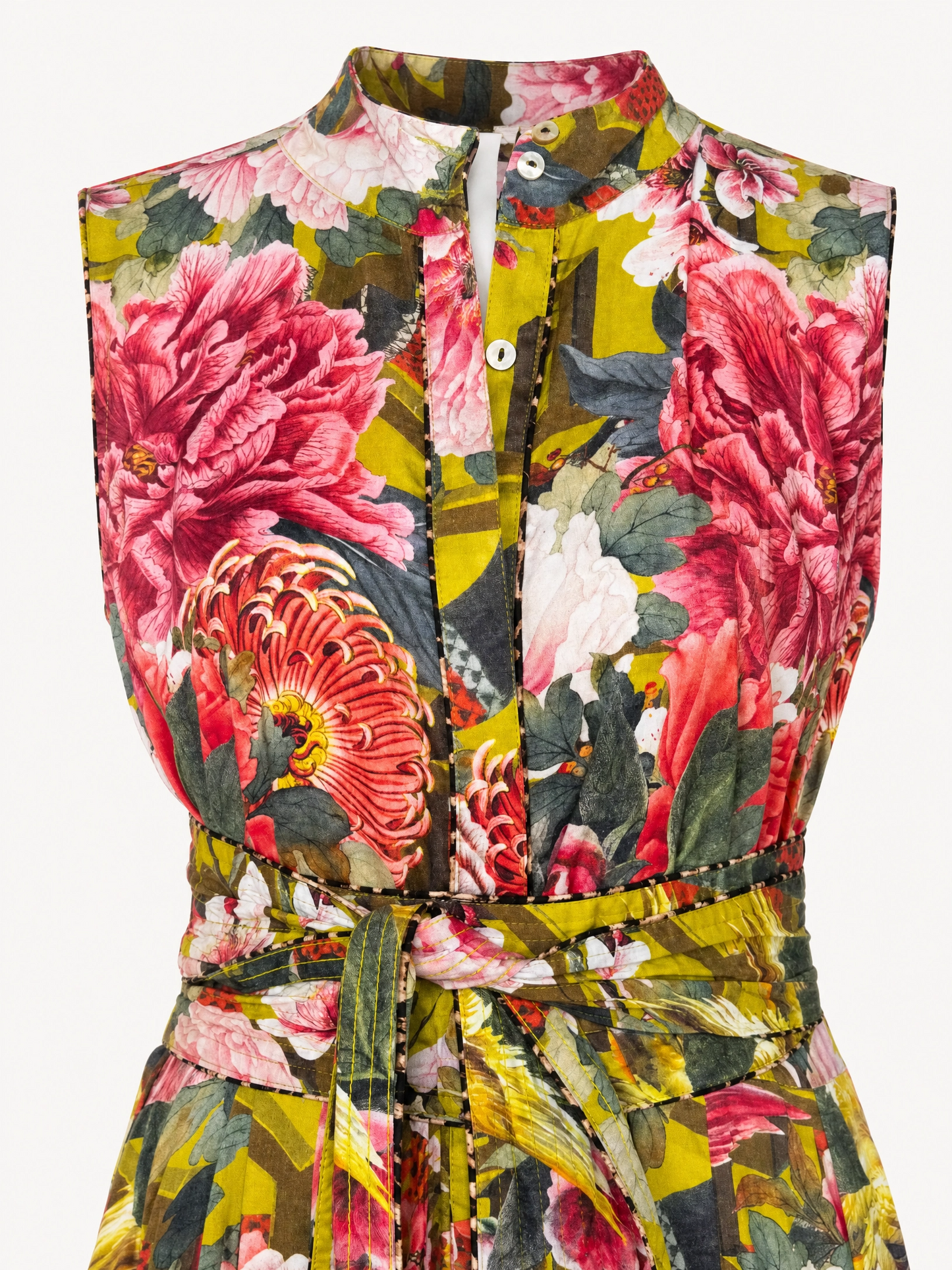 A sleeveless button-front top or dress with a bold floral print in pink, red, green, yellow, and white, featuring a high collar and a matching waist tie.