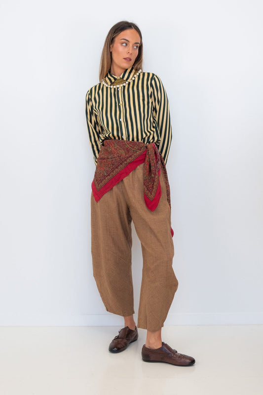 Model wearing Chocolate Prince of Wales barrel pants with a striped shirt and red scarf tied at the waist.