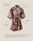 A floral belted dress with balloon sleeves and a Chinese collar, shown on a textured beige background with handwritten callouts and descriptive text. The dress features a bold multicolor floral print with pink, red, green, and blue tones.