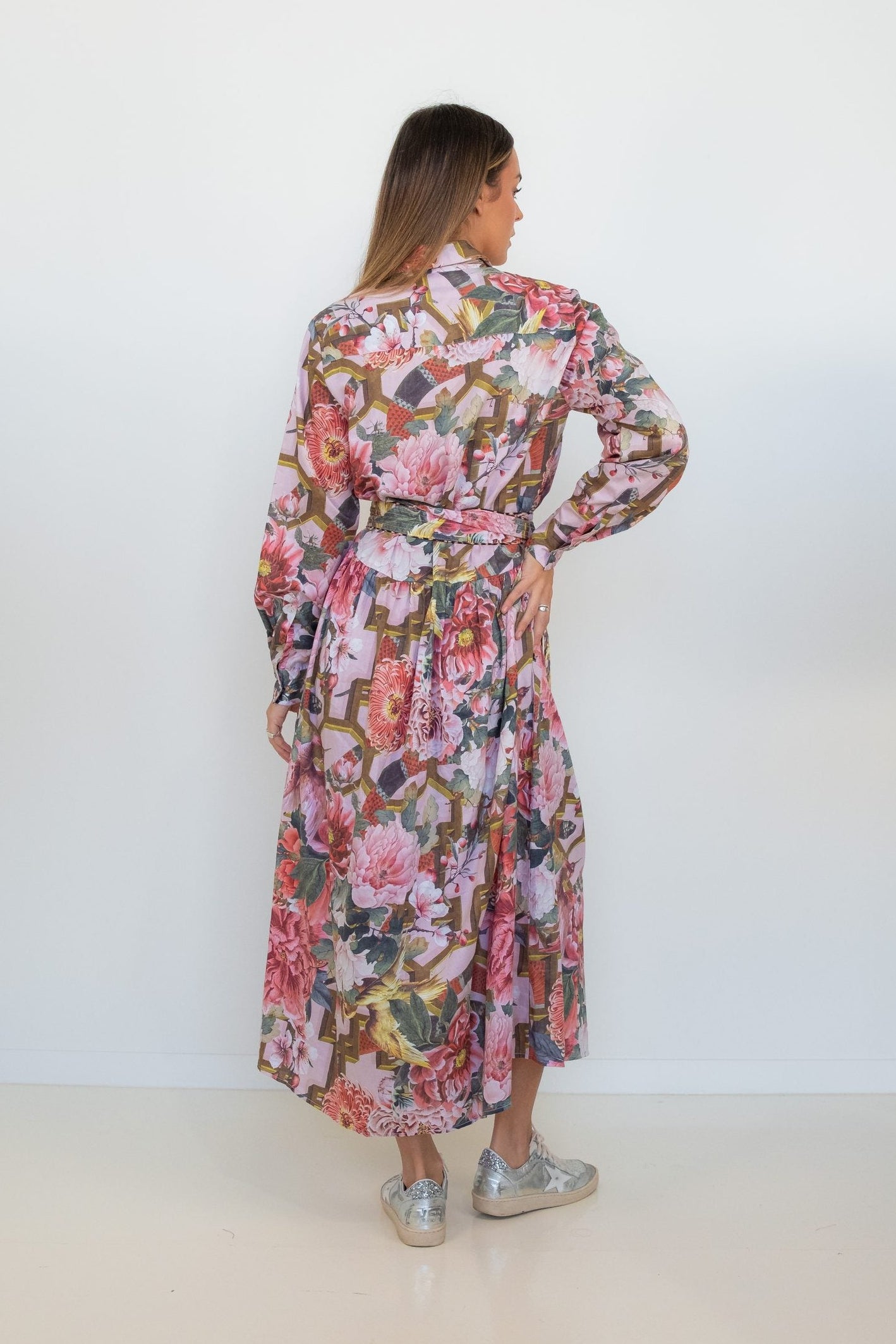 Back view of a model wearing the Ophelia pink floral-and-chain print drop-waist dress.