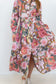 Front view of the pink floral-and-chain print drop-waist dress with the skirt slit open.