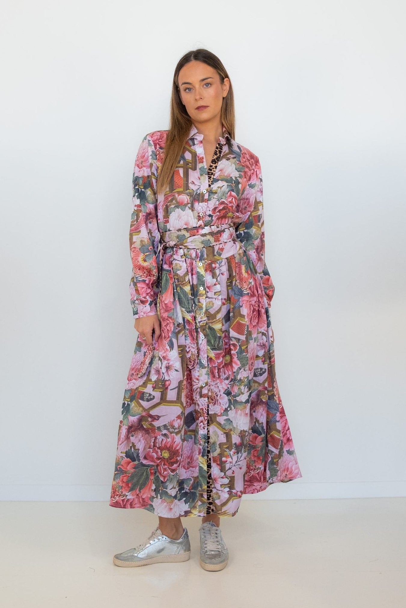 Full-length front view of a model wearing the pink floral-and-chain print drop-waist dress with long sleeves.