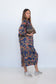 Side view of a model carrying a woven bag while wearing the Ophelia Snakes Butterfly Dress.