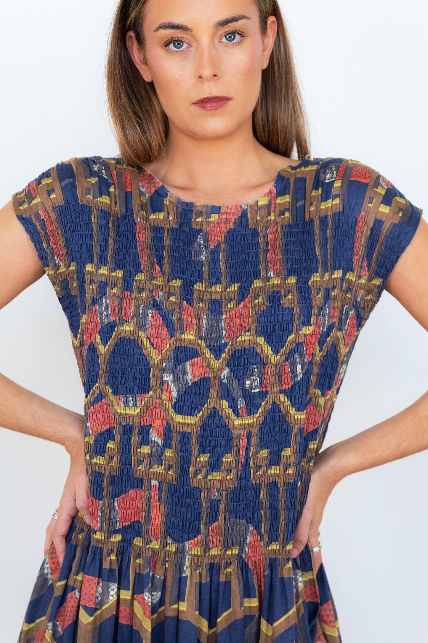 Close-up front view of the navy snakes-and-florals print on the smocked bodice.